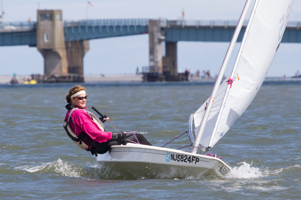 woman-sailing-laser-boat-under-bridge-ADULT-SAILING-Avalon-Yacht-Club