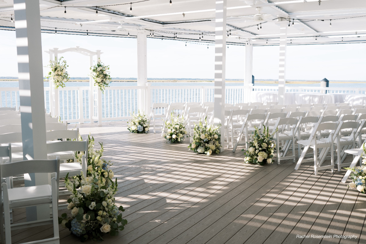Wedding-ceremony-setup-white-chairs-floral-decor-WEDDING-&-EVENTS-Ceremonies-Avalon-Yacht-Club